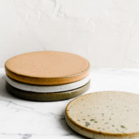 2: A set of four round ceramic coasters in earthy color mix.