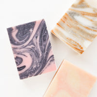 2: Three marbled bar soaps in black and pink, pink and beige, and white and orange.