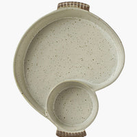 2: An asymmetrical serving dish with divided sections for chips and dip.