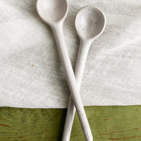 3: A stoneware spoon in white with dark speckles.