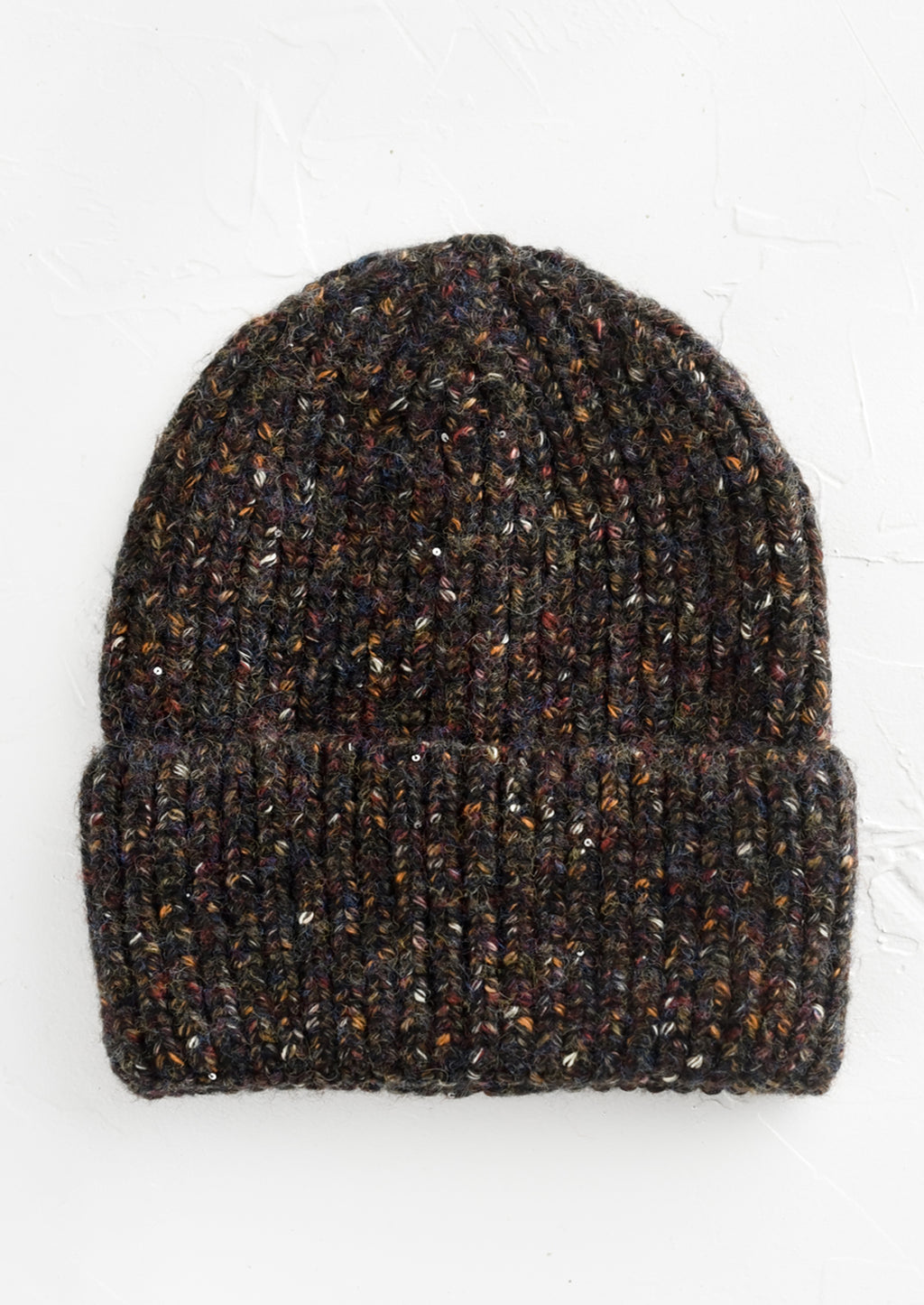 Charcoal Multi: A knit beanie hat with cuffed rim made in black yarn with earth tone speckles.