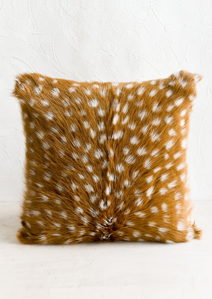 1: A goat fur pillow in sable brown with white spots throughout.