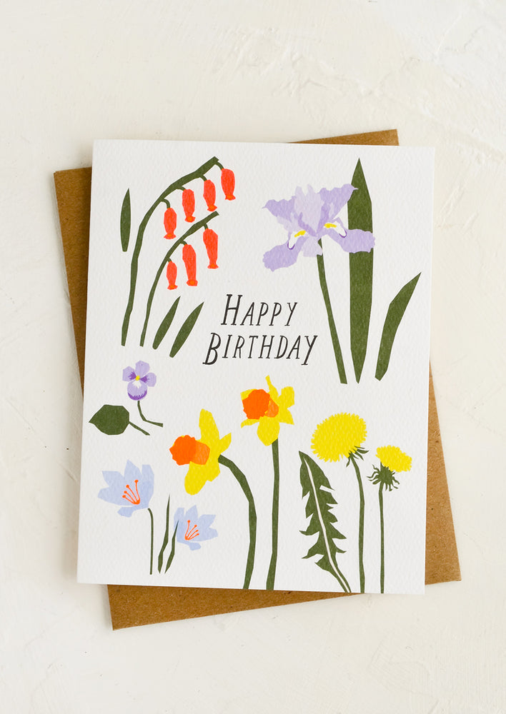 A birthday card with floral print and kraft envelope.