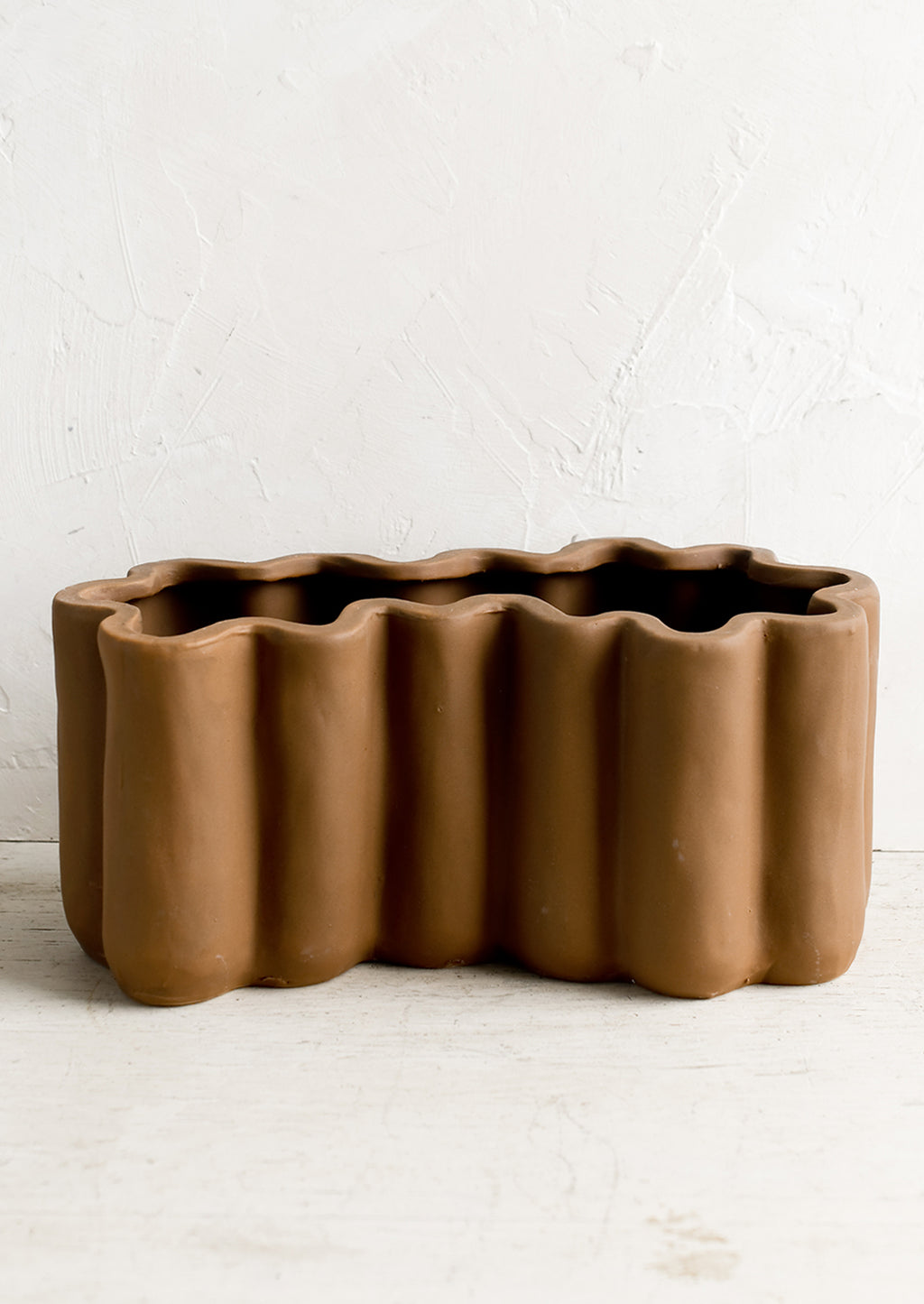 2: A brown ceramic planter in squiggle shape.