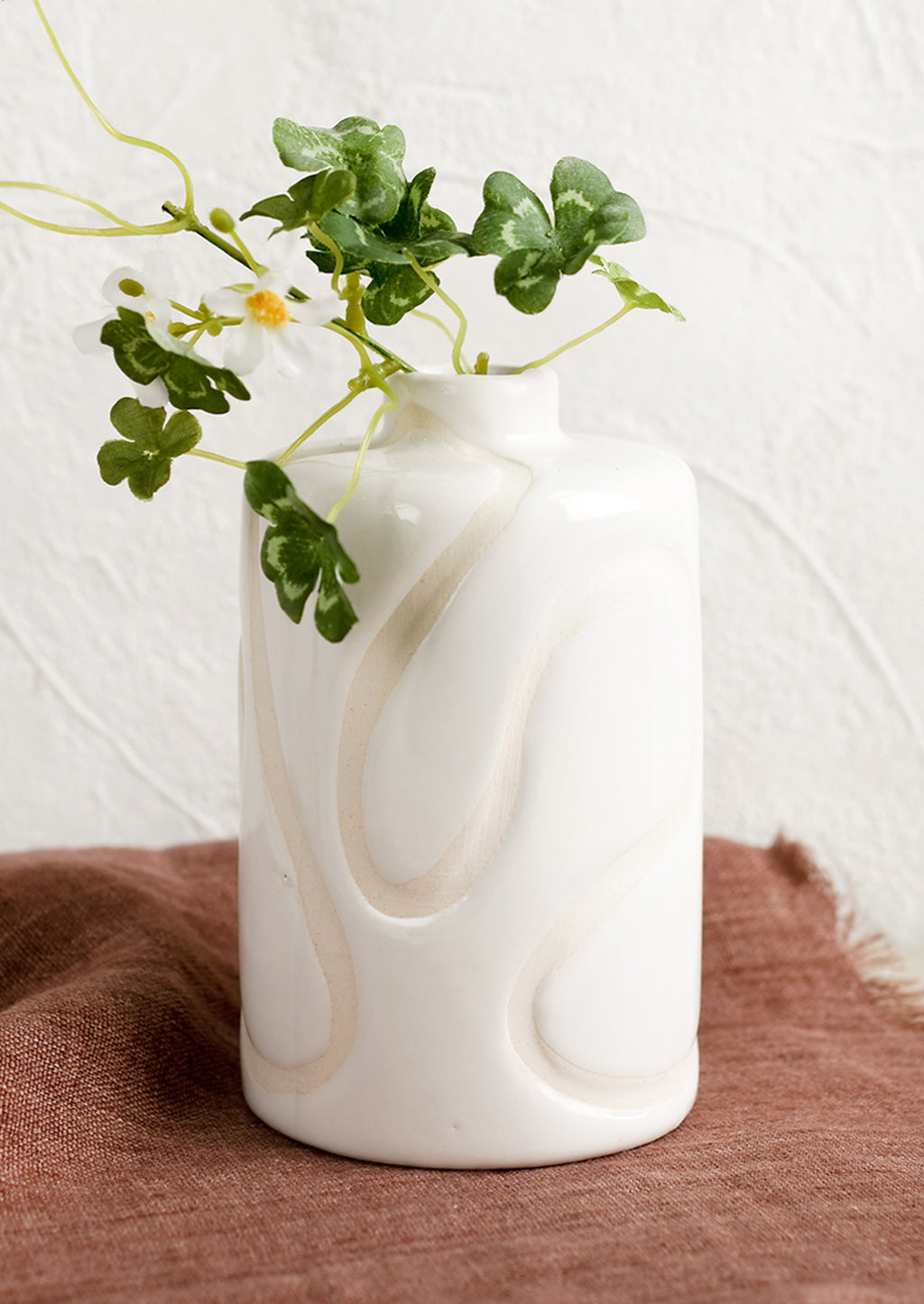2: A glossy white ceramic vase with subtle cream squiggle design.