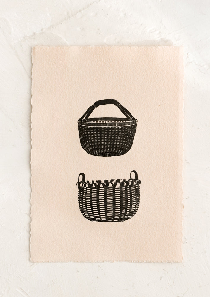 A deckled edge peach art print with two black letterpress baskets.