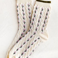 1: A pair of cream socks with purple flower vertical lines.