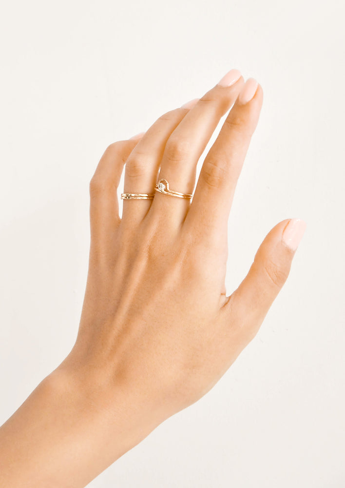 Woman's hand with rings on her ring and middle fingers.