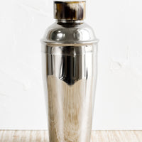 1: A stainless steel cocktail shaker with horn cap.