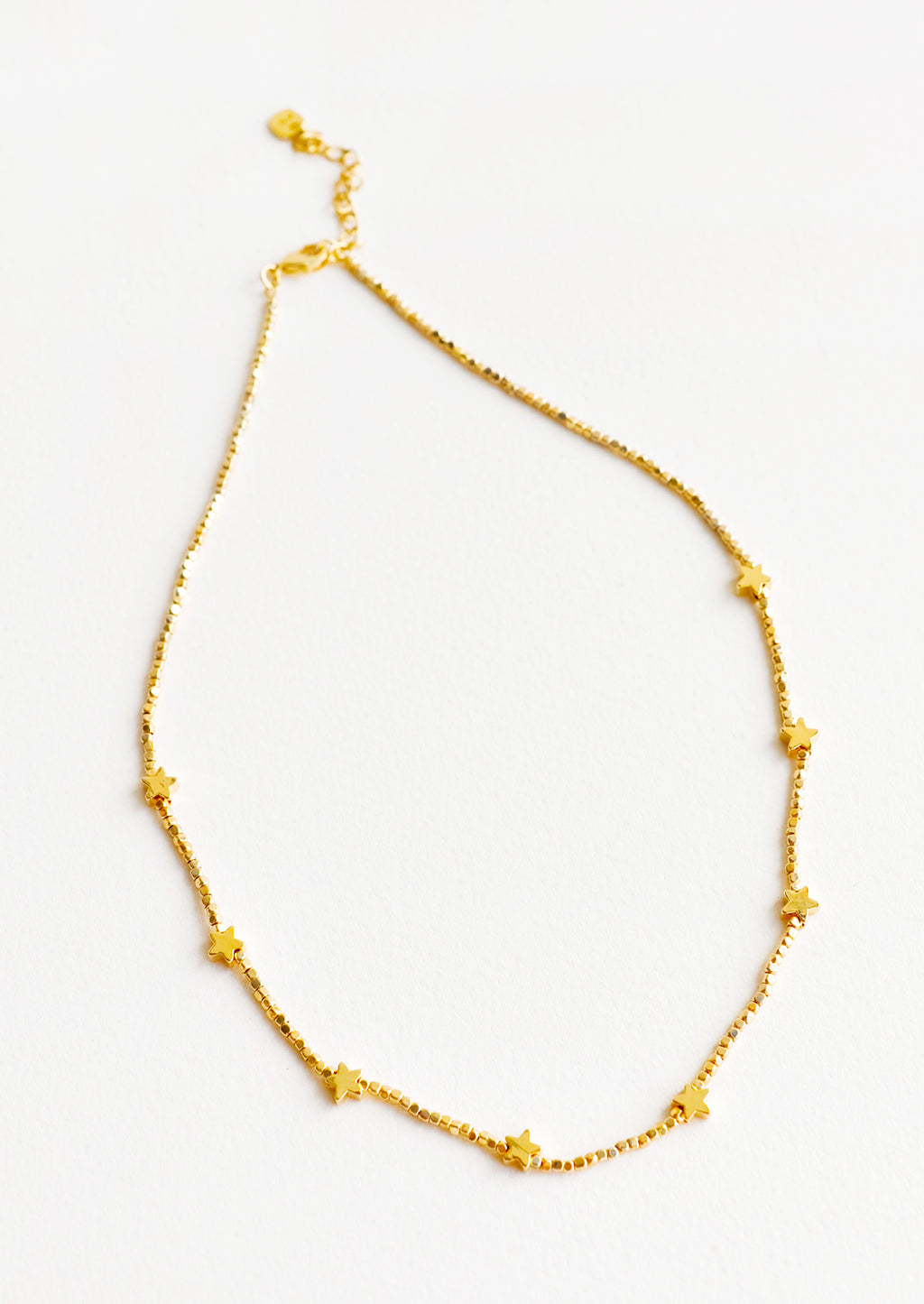 1: Short necklace featuring round yellow gold beads interspersed with gold star beads and an adjustable closure.