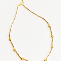 1: Short necklace featuring round yellow gold beads interspersed with gold star beads and an adjustable closure.