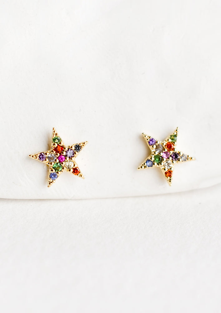 1: A pair of star shaped gold stud earrings with multicolor crystal pave.