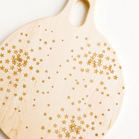 1: Round paddle-style cutting board in maple wood with scattered star pattern
