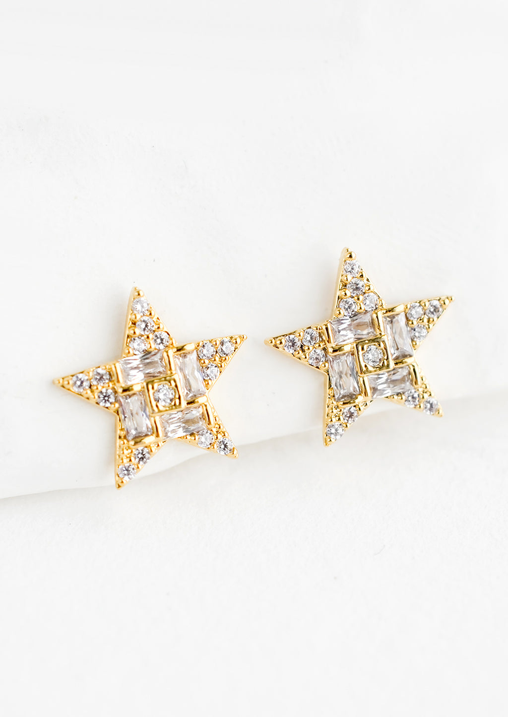 1: A pair of gold star shaped stud earrings with crystal pave detailing.
