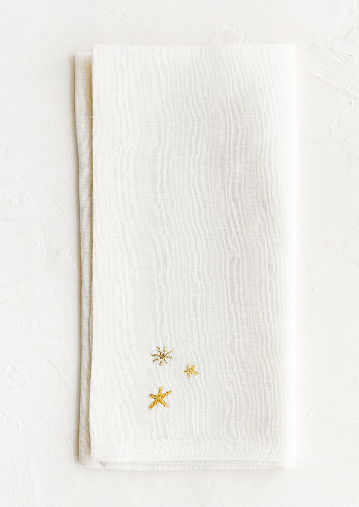 A white napkin with three embroidered stars.