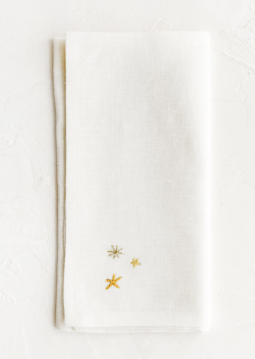 1: A white napkin with three embroidered stars.