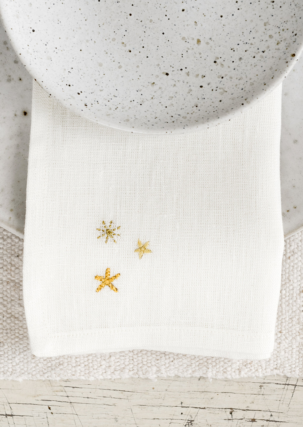 2: A white napkin with three embroidered stars.