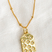1: A gold tag charm necklace with crystal pave star detailing.