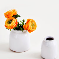2: Round, white, rustic ceramic vases in glossy finish, pictured with orange flowers