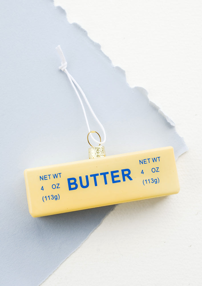A holiday ornament designed to look like a realistic stick of butter in its paper wrapper.