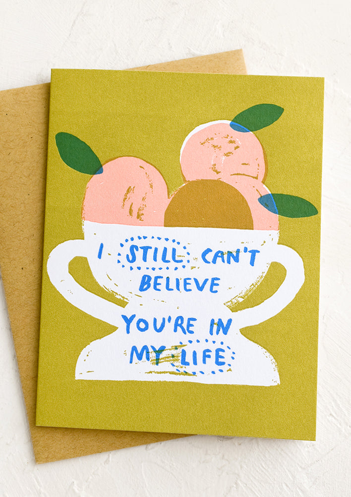 A card with still life image of fruit in a bowl, text reads "I still can't believe you're in my life".