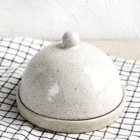 2: A round stoneware butter dome.