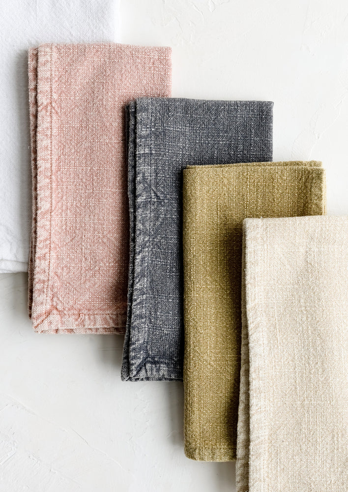 A stack of stonewashed cotton napkins in assorted colors.