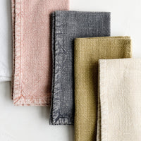 1: A stack of stonewashed cotton napkins in assorted colors.