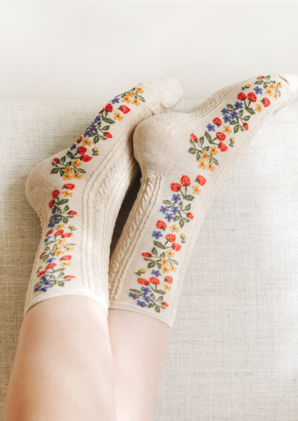 3: A pair of oatmeal colored socks with primary color strawberry print.