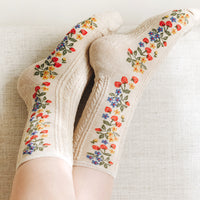 3: A pair of oatmeal colored socks with primary color strawberry print.