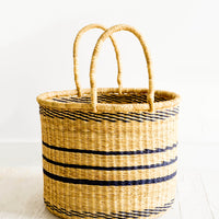 Small: Round straw storage basket with handles at top and navy blue stripes throughout