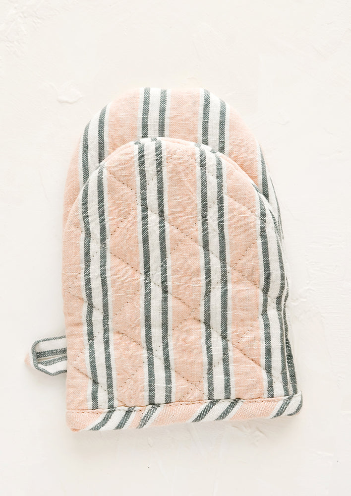 A quilted oven mitt made from pink, indigo and white striped linen.