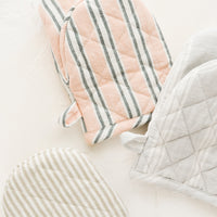 2: Three quilted oven mitts made from different colors of striped linen.