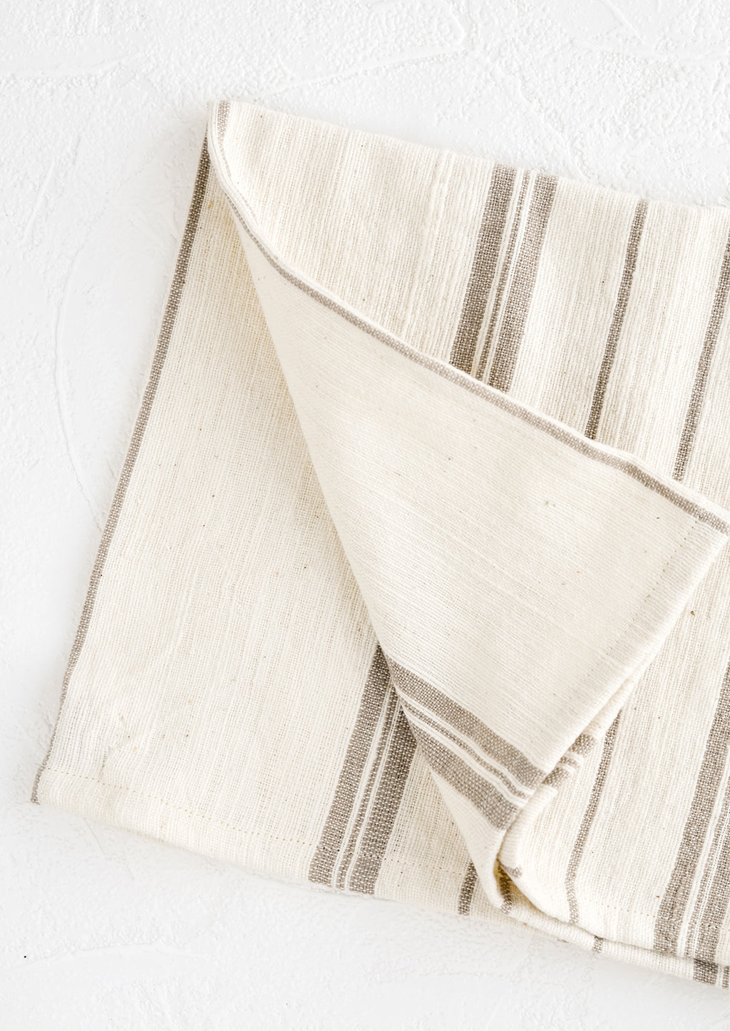 Sand: A folded natural cotton hand towel with taupe stripes.