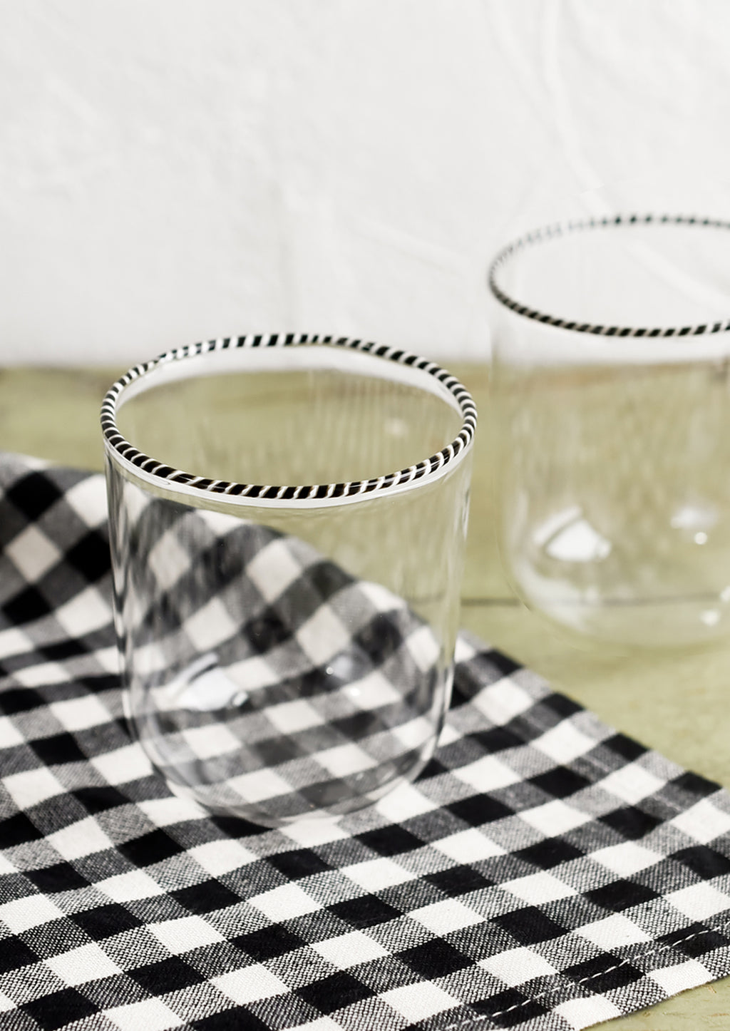 Clear: A pair of clear glass tumblers with black and white striped rim.