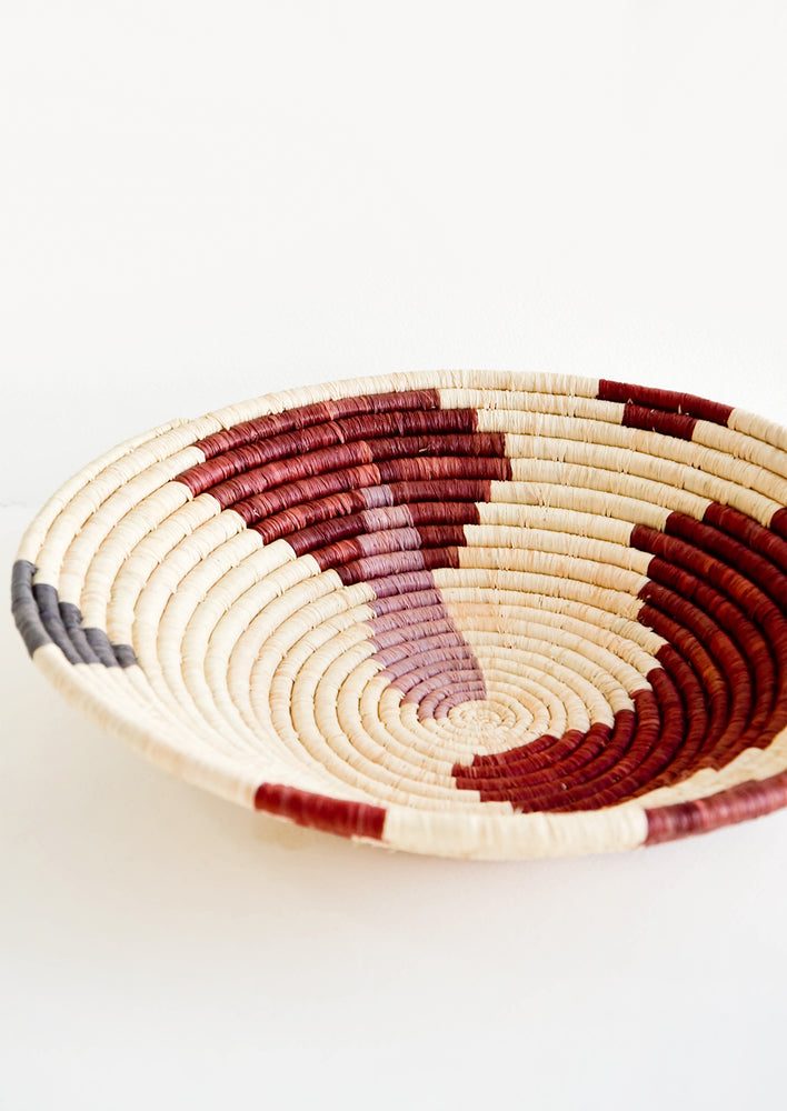 2: Shallow woven raffia bowl with abstract pattern in lavender, wine and charcoal