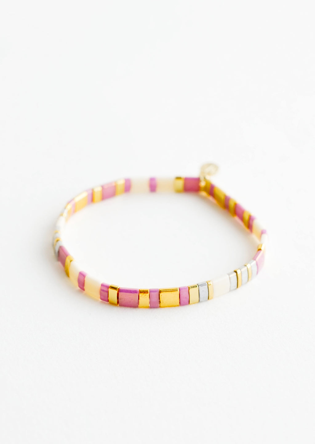Lavender Cream: Bracelet featuring flat multicolor purple and cream glass beads interspersed with flat gold bead on an elastic cord.