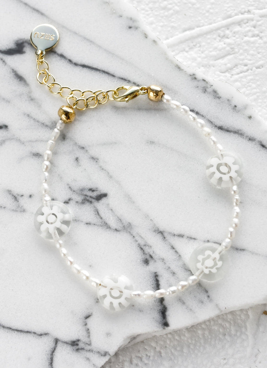White Flowers: A pearl beaded bracelet with clear millefiore glass daisy beads.