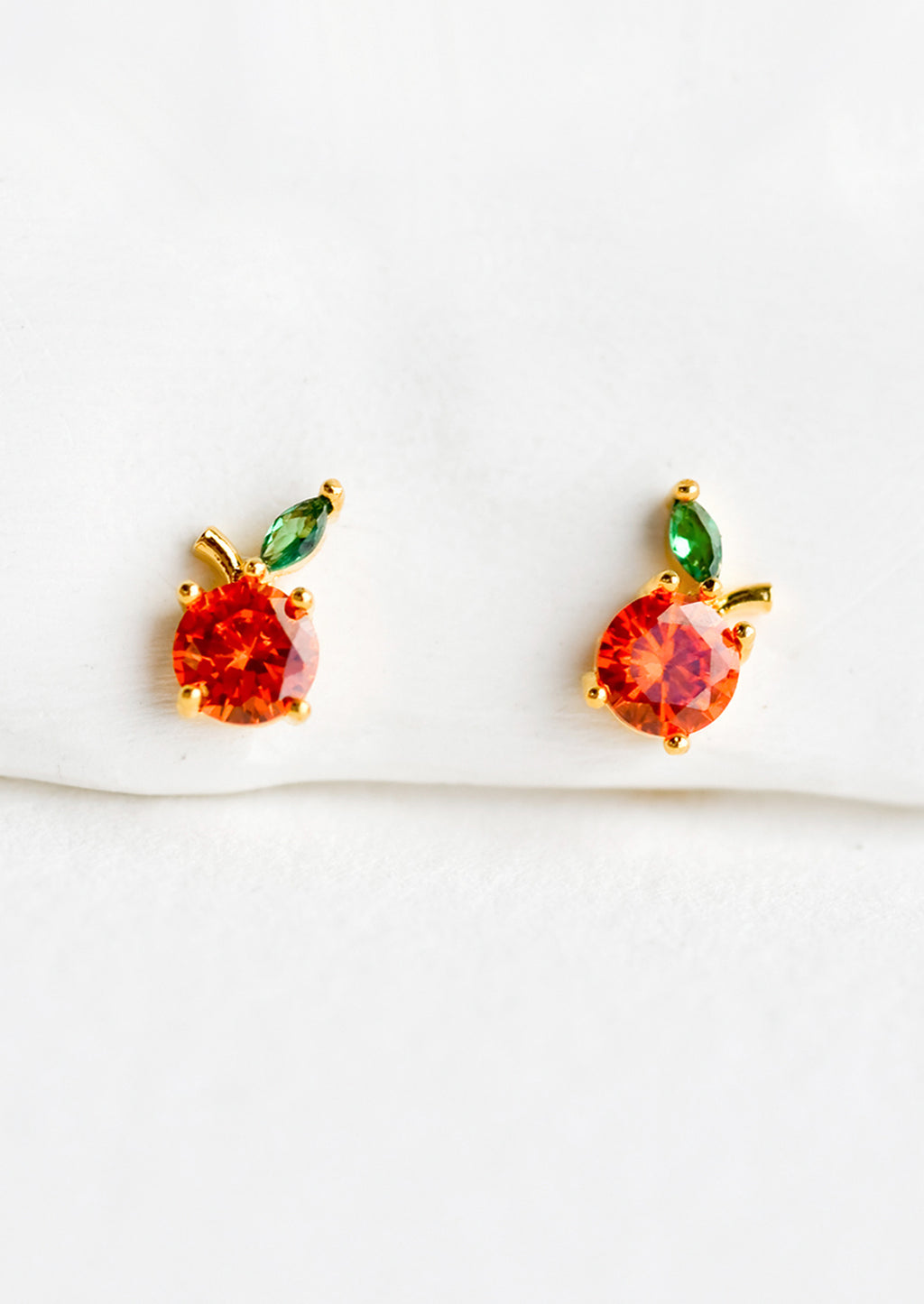 Orange: A pair of small crystal stud earrings in the shape of oranges.