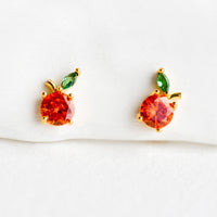 Orange: A pair of small crystal stud earrings in the shape of oranges.