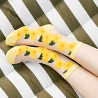 1: A woman's ankles on a hammock wearing sheer sunflower socks.
