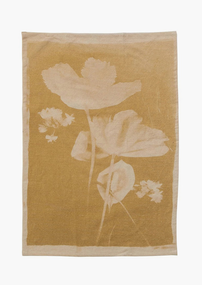 A yellow cotton tea towel with "bleached" look floral print.
