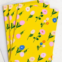 1: A set of yellow greeting cards with colorful floral print.