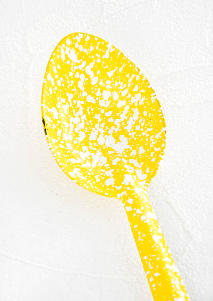 2: Metal spoon with splattered yellow and white enamel coating