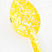 2: Metal spoon with splattered yellow and white enamel coating