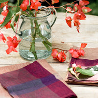 2: A pair of color overlay linen napkins on a table.