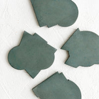Petrol: Four concrete coasters in petrol blue-green color with unique abstract shapes.