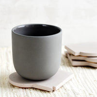 Pale Mauve: A ceramic cup on top of a coaster.