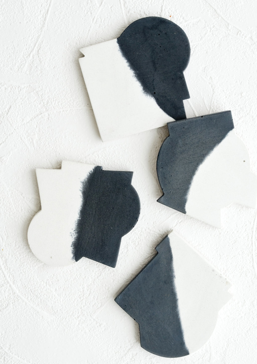 Black & White: Four concrete coasters in black & white color with unique abstract shapes.