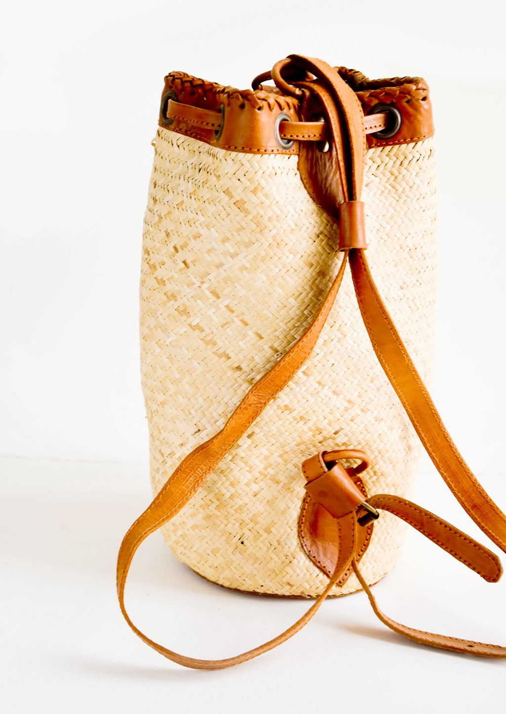 2: Tall and round woven straw bag with tanned leather backpack straps